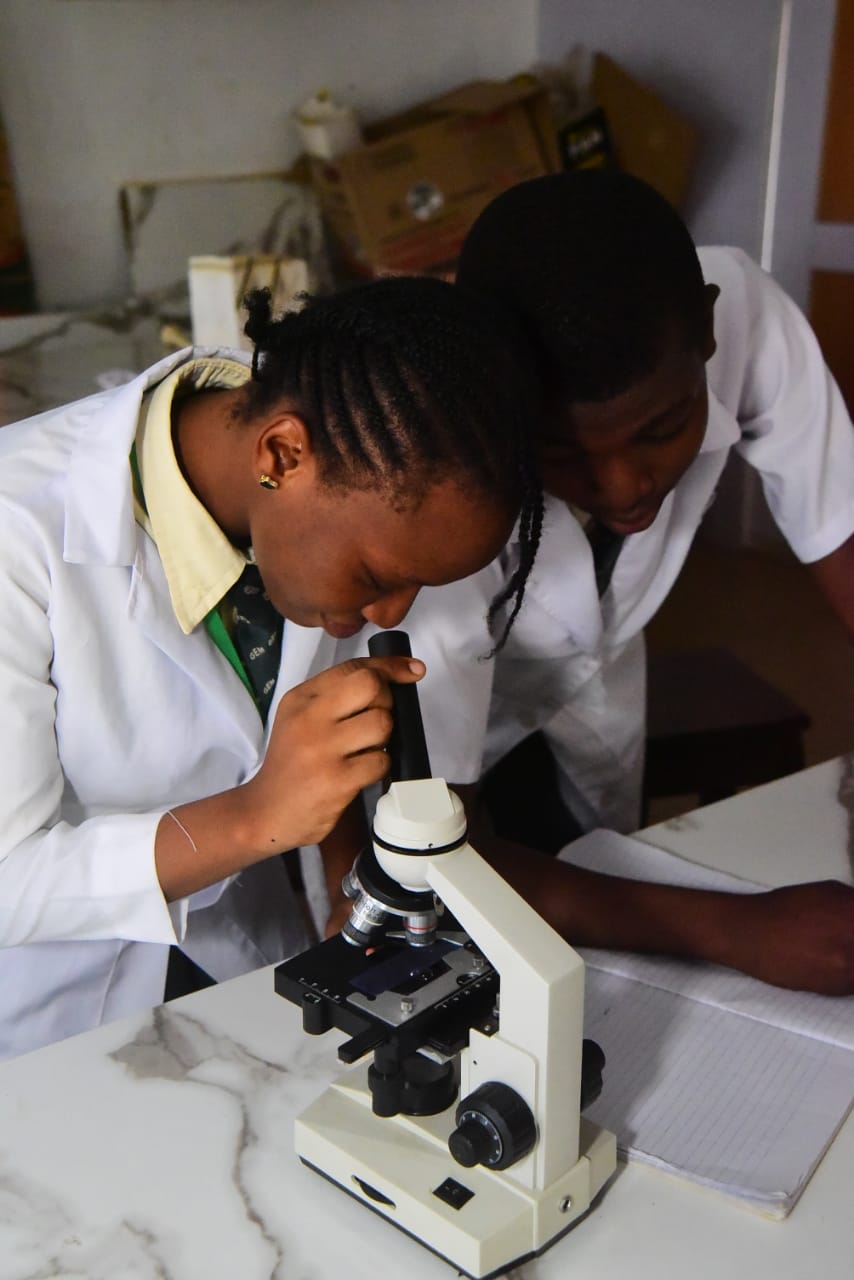 Students Using Microscope in Science Lab